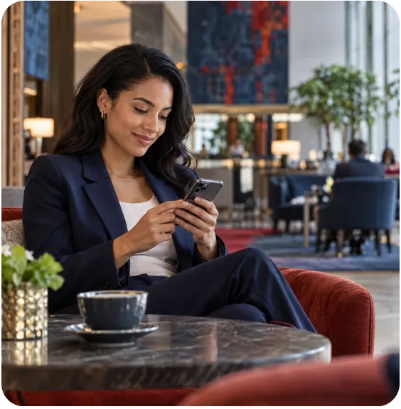A guest in a hotel lounge using her phone on the venue WiFi.
